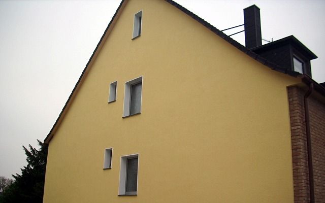 Giebelwand eines Wohnhauses, frisch in kräftigem Gelb gestrichen