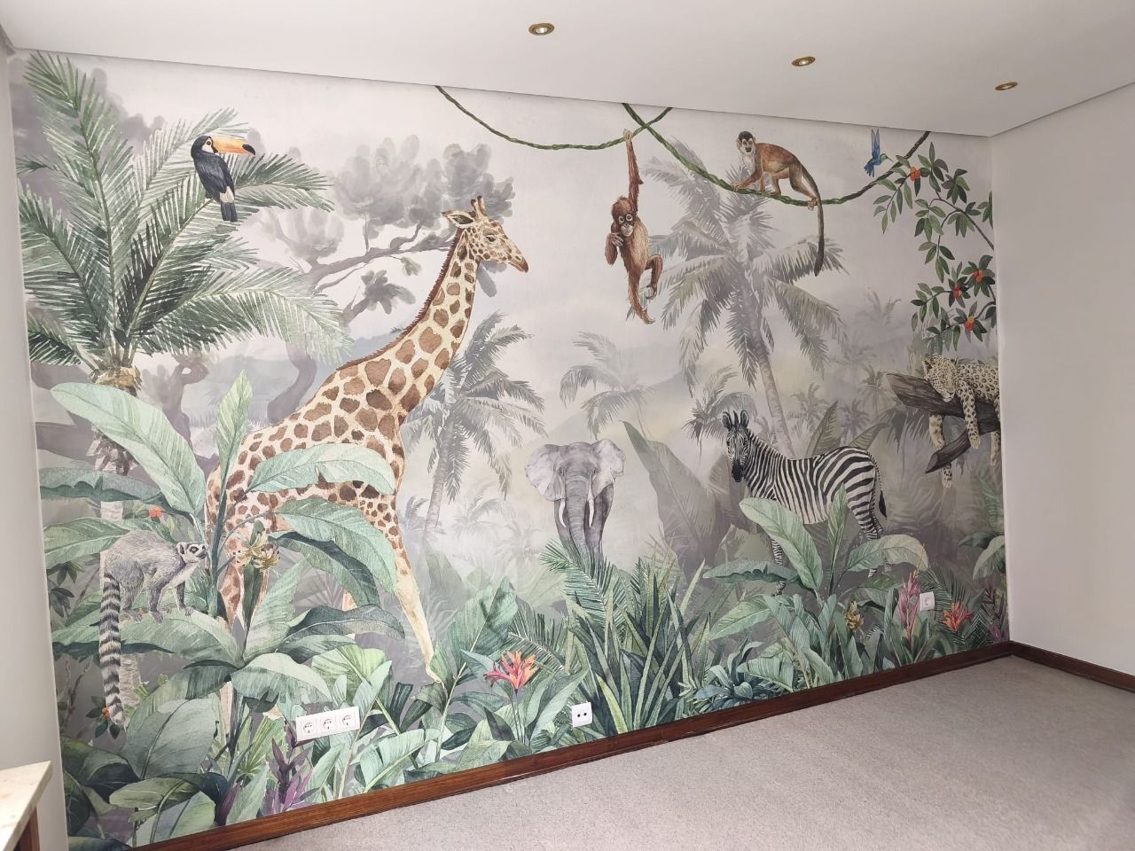 Leerer Raum mit raumhoher Tapete, die einen Dschungel mit Giraffe und Affen zeigt