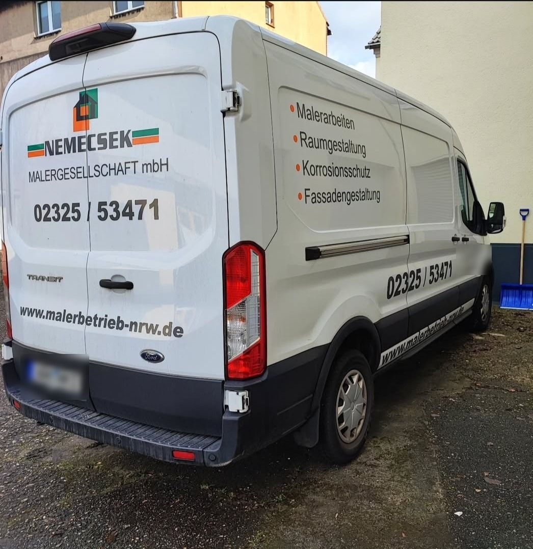 Weißer Transporter der Nemecsek Malergesellschaft mit Hausmarke, Telefonnummer und Leistungen auf der Seite
